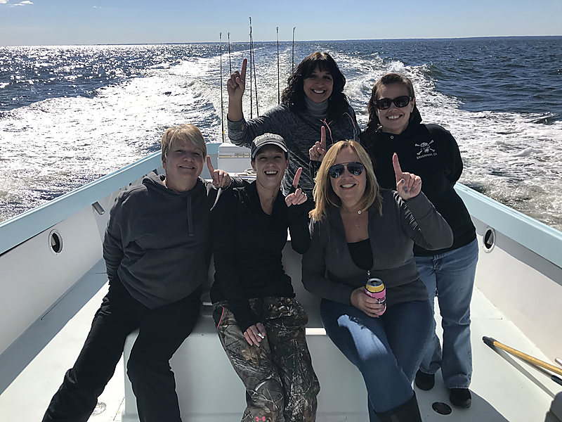 Five friends on the deck with the wake behind them