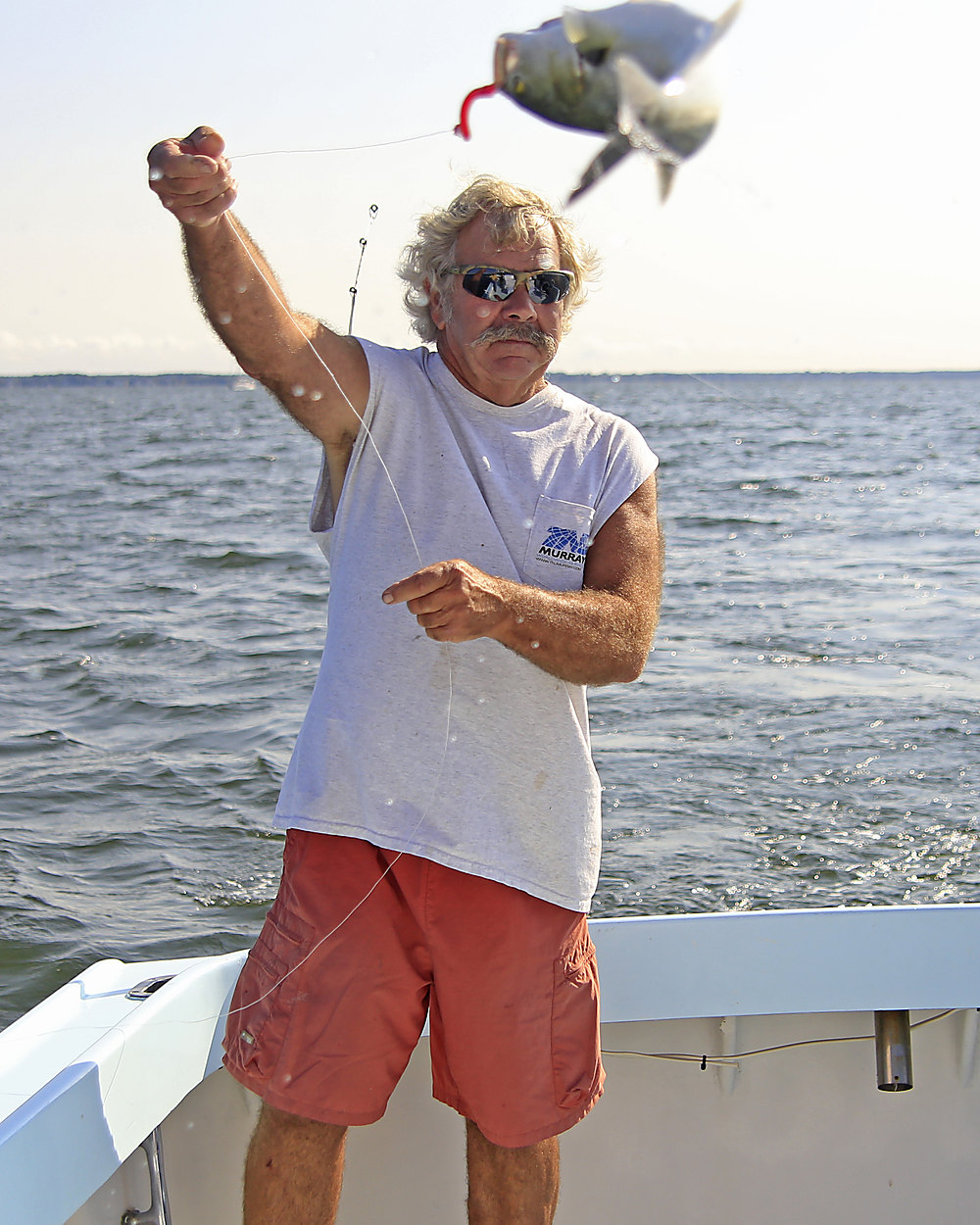 On the Class Act deck, tossing a fish to the gulls on the way in